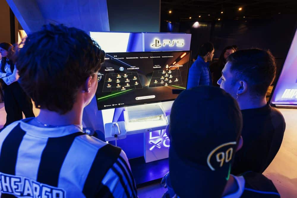 Group of gamers engaged in a PS5 event, choosing teams on a football game selection screen.