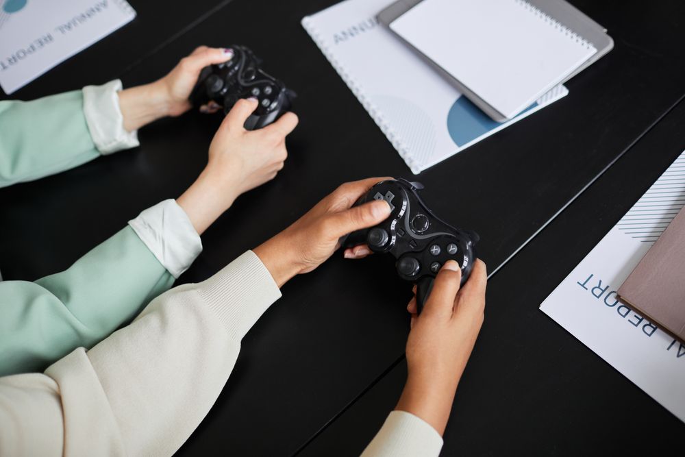 Two people playing video games with controllers, highlighting teamwork and gaming experience.