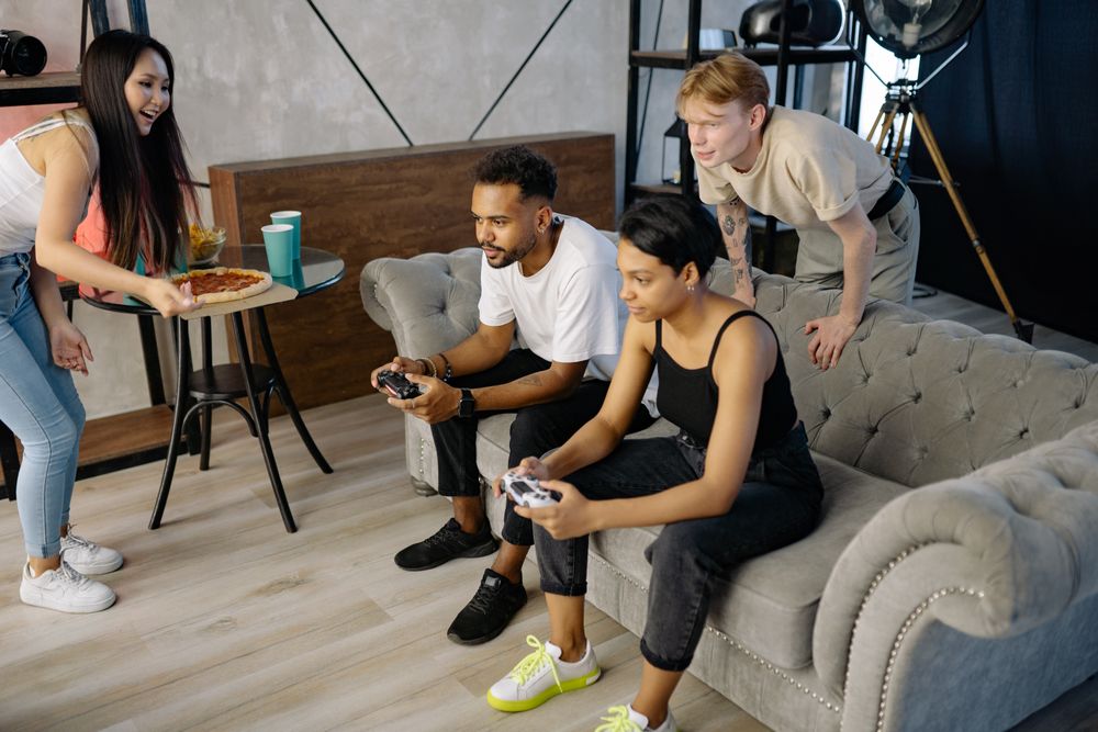 Diverse group of friends enjoying video games together in a cozy home setting.
