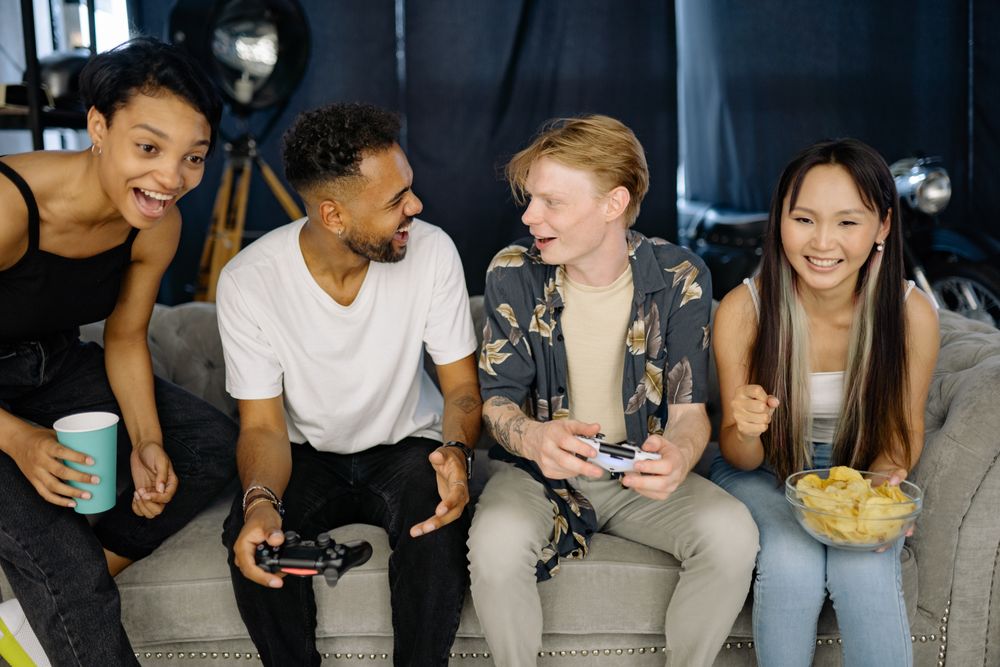 A group of diverse friends enjoying a video game session together, laughing and bonding indoors.